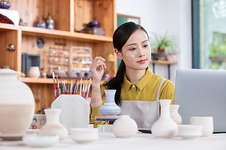 美女工匠绘制陶艺瓶图片