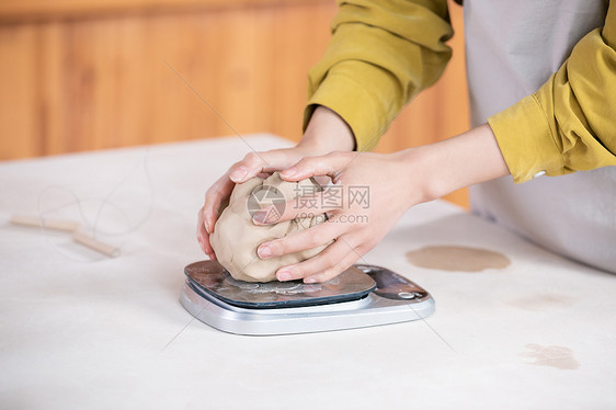 美女给陶土称重特写图片