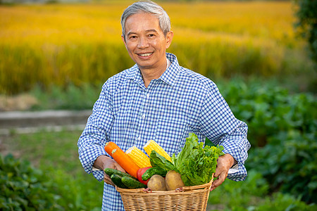 玉米胡萝卜农民开心的抱着一篮子蔬菜背景