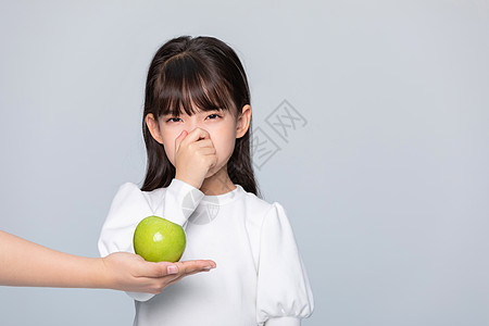 小孩吃水果小女孩挑食不想吃水果背景