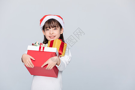 抱着礼物女孩小女孩抱着收到的圣诞礼物背景