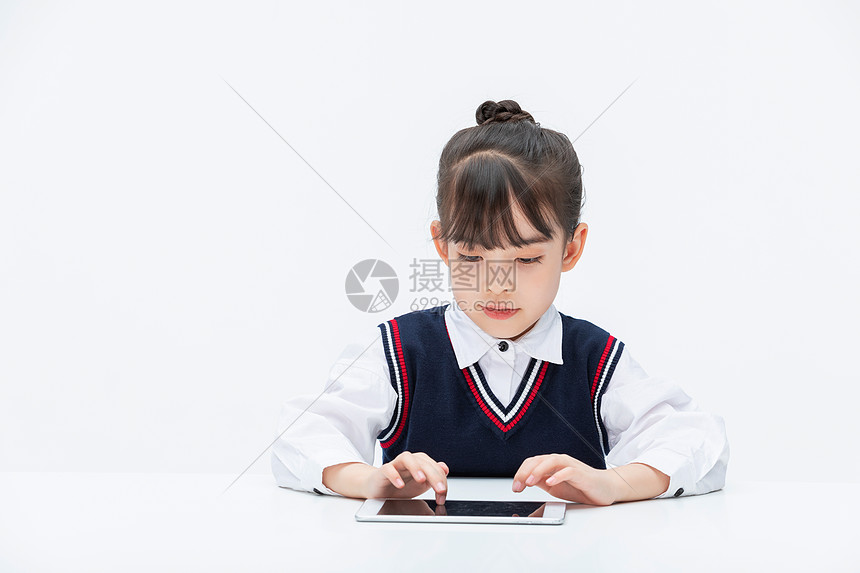 小女孩在课桌前使用平板电脑图片