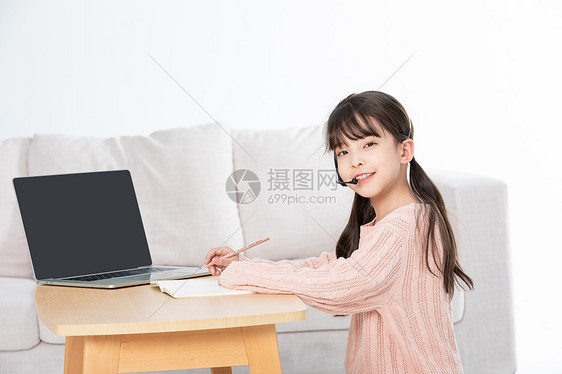 小女孩使用电脑线上学习听课做笔记图片