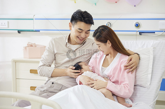 医院产房年轻夫妻和新生婴儿宝宝温馨互动图片