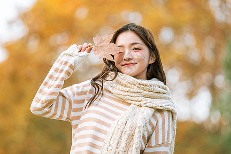 手拿树叶秋季可爱女孩手拿枫叶的背景