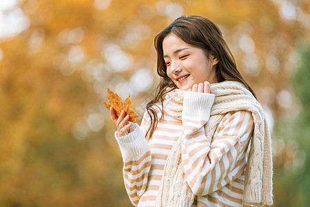 一片树叶秋季可爱女孩手拿枫叶的背景