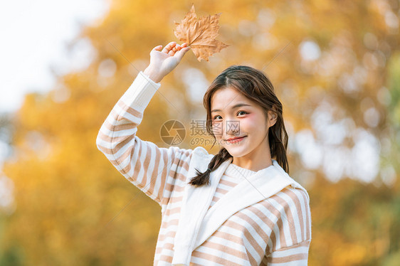 手拿树叶的秋季可爱女孩图片
