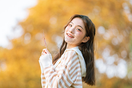 手拿树叶的秋季可爱女孩图片