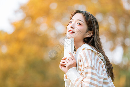 手捧黑土手捧书本的清新文艺秋季美女背景