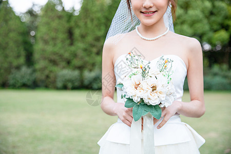 婚纱模特拿手捧花的甜美新娘特写背景