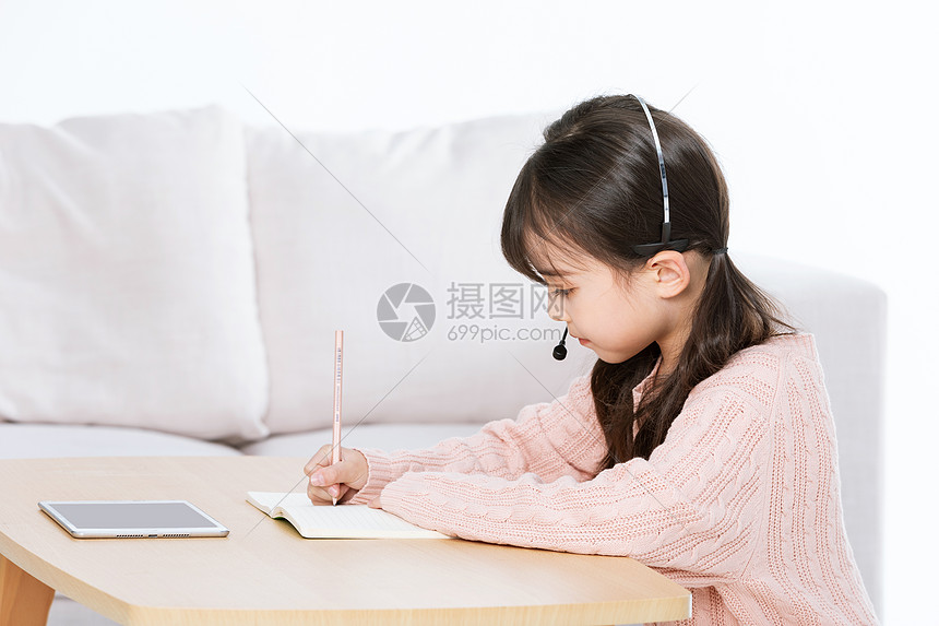 小女孩使用平板电脑学习做笔记图片