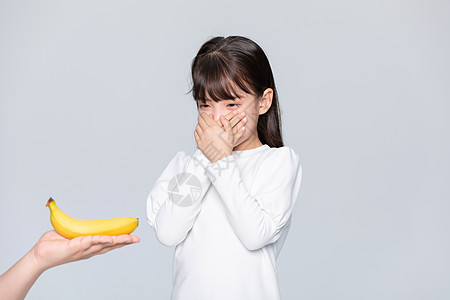 小女孩捂着嘴不愿意吃香蕉图片