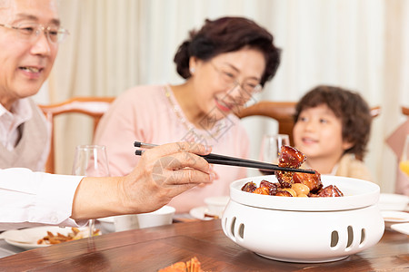 新春家庭年夜饭夹菜红烧肉特写高清图片