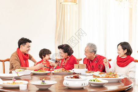 新春年夜饭奶奶夹菜喂小男孩图片