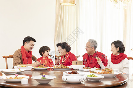 新春年夜饭奶奶夹菜喂小男孩高清图片