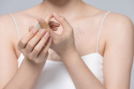 女性手受伤使用创可贴特写图片