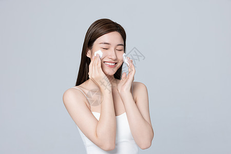 皮肤管理美女开心的使用泡沫清洁脸部背景