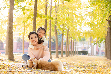 母女两人一起在树林和宠物嬉闹图片