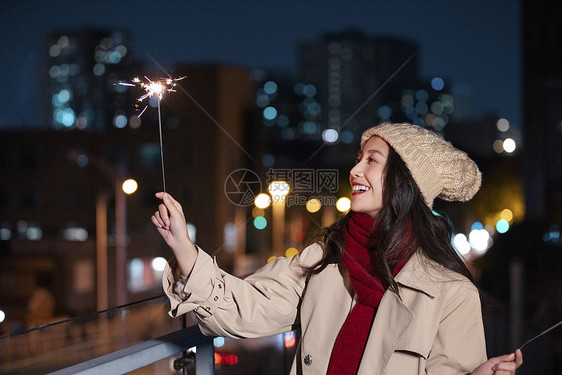 秋冬夜晚美女过圣诞节放烟花棒图片