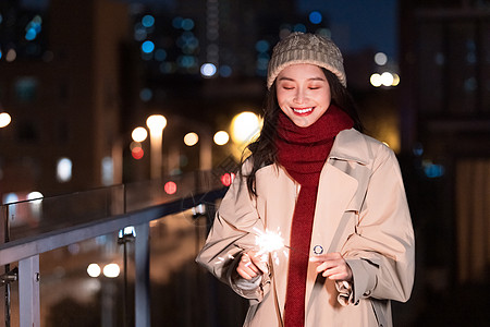 秋冬夜晚美女过圣诞节放烟花棒图片