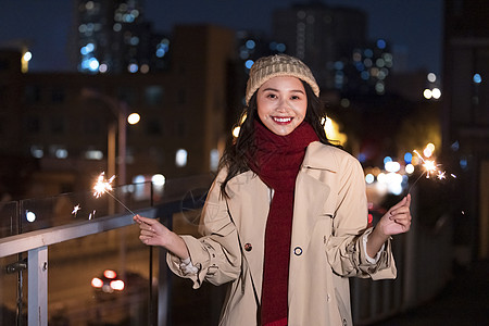 秋冬夜晚美女过圣诞节放烟花棒图片