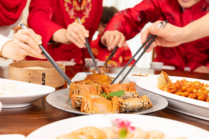 新春家庭团圆年夜饭夹菜吃大闸蟹特写图片