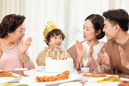 一家人吃蛋糕一家人欢乐地为小男孩庆祝生日背景