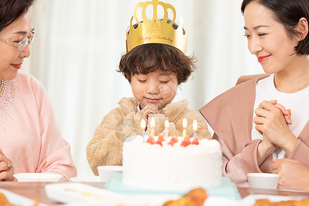 陪伴老人的孩子过生日的小朋友对着生日蛋糕许愿背景
