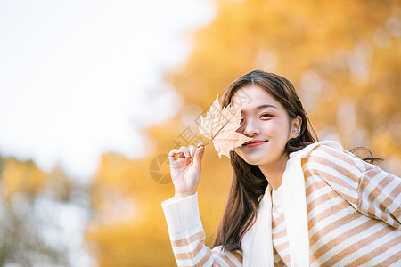 手拿树叶的秋季可爱女孩背景