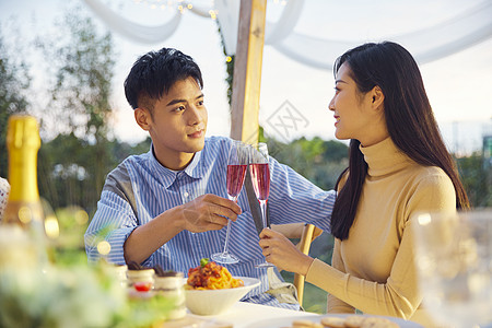 年轻情侣约会喝酒碰杯高清图片