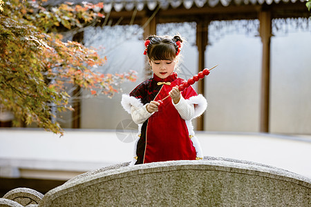 拿糖葫芦的女孩中国风儿童新年拿糖葫芦逛公园背景