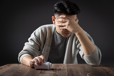 危机管理抑郁拿着药瓶内心纠结的男性背景