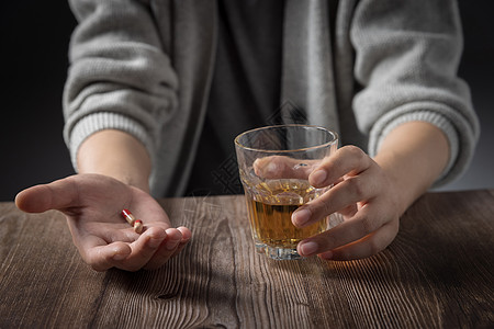 手里拿着药和酒杯的男性特写高清图片