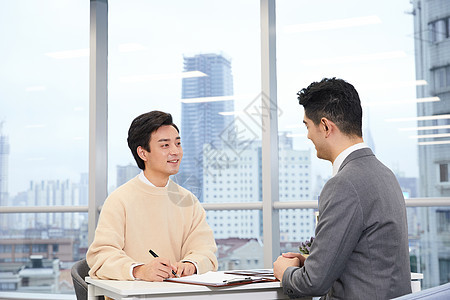 青年男性与房产销售签订合同图片