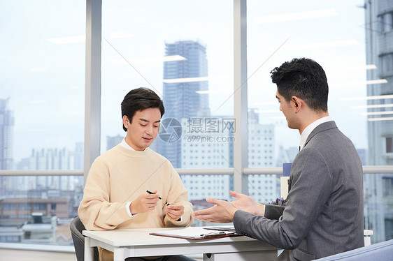 青年男性与房产销售签订合同图片