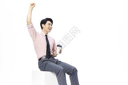 年轻商务男士手拿咖啡杯庆祝动作图片