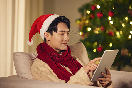 阳光男生圣诞节在家玩平板电脑图片