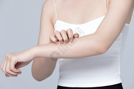 皮肤过敏抓挠手臂的女性图片