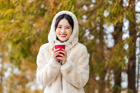 秋冬户外手捧咖啡的美女图片