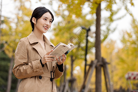 知性女青年手捧书本户外阅读图片