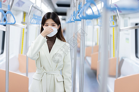 女性在地铁上调整口罩图片