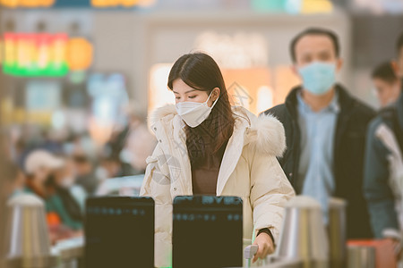 冬天高铁素材戴着口罩排队检票进站的女性背景