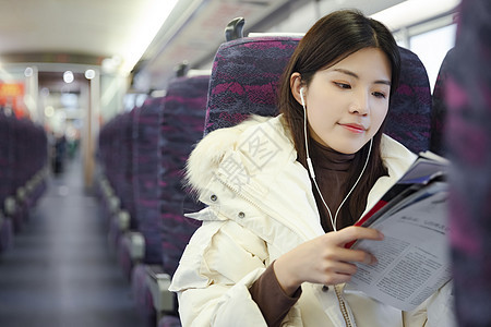 女性坐在空荡的车厢里看杂志图片