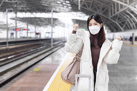 子弹头列车戴口罩的女性在列车站台做加油动作背景