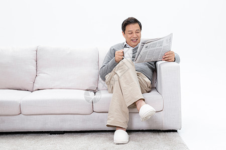 老人坐在沙发上享受咖啡看报纸高清图片