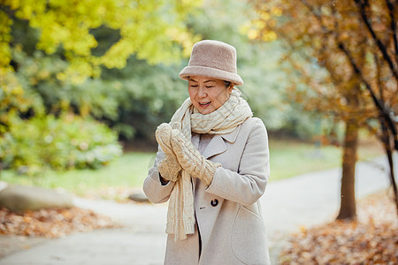 秋冬季节老奶奶逛公园戴手套保暖背景图片