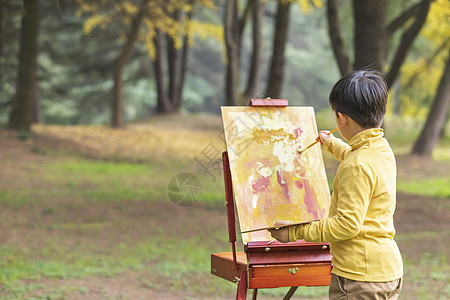 秋季儿童公园里拿调色盘绘画背景图片