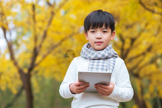 秋季儿童公园里休闲看书图片