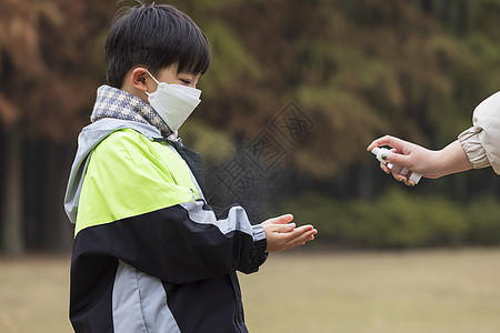 老年模特秋冬小男孩疫情期间逛公园手部消毒背景