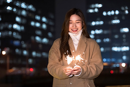 秋冬夜晚美女室外放烟花高清图片